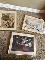 Three framed original paintings by M. Laufer arranged on carpet showing floral and landscape themes, various color palettes.