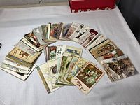 Wide shot of 100+ vintage New Year's and Christmas postcards spread in a semi circle showing various colorful illustrations and holiday themes.