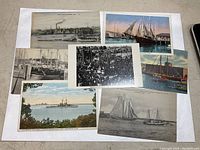 Seven antique postcards arranged overlapping, showing maritime scenes including sailing ships, military ships, and harbor views.