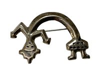 Front view of the brooch showing its abstract figure design with stamped decoration and patina.