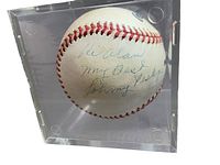 Front view of live ink signed baseball with visible inscription inside clear protective display case.