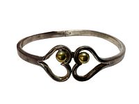 Front view of the sterling silver bracelet showing heart-shaped clasp with gold tone spheres.
