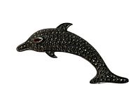 Front view of the dolphin brooch showing the marcasite stones and garnet-colored eye.