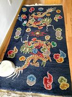 Full view of navy rug displaying central dragon motifs