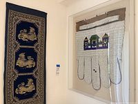 Overall view of both wall hangings side by side on a wall