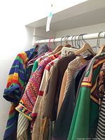 Photo of various colorful ethnic dresses and robes hanging on a clothing rack.