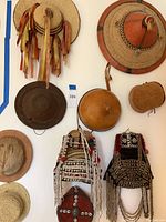Overview of eight hats and headpieces arranged on wall
