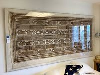 Front view of framed mud cloth wall hanging on wall