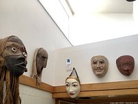 Overview of all five masks mounted on wall