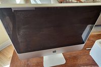 Front view of Apple iMac showing 20 inch display with some dust and smudges on screen