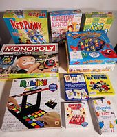 Front view of various kids board games and card games arranged together, showing titles and packaging.