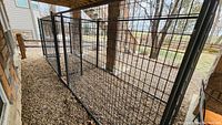 Overview of combined kennel panels set up along stone patio under porch.