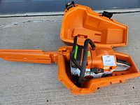 Chainsaw loaded in open orange case showing saw and bar