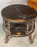Photo of a 1970s-era round wooden end table with a 17-inch diameter top, showing multiple surface cracks and worn finish.