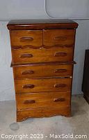 Photo of vintage wooden bureau showing six drawers and scallop detail on top drawers.