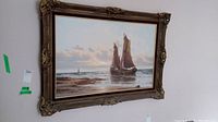 Full view of framed oil painting showing sailboat seascape and ornate frame