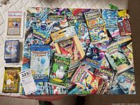 Full view of 16×20 canvas with scattered sealed booster packs, PSA slab and bulk card pack