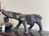 Side view of the wooden bull statue showing overall shape and posture