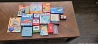 Overview of 17 mini games arrayed on a wooden table showing multiple small boxed games.