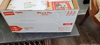 Box containing packages of Xerox Revolution Premium Digital Carbonless Paper on a table.