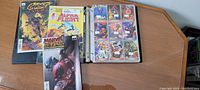 27 sheets of collector cards in a binder along with 3 Marvel comic books including Ghost Rider, Alpha Flight, Marvel Zombies Resurrection