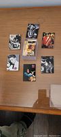 Seven Elvis collector cards laid out on a wooden surface.