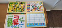Full view of all four wooden magnetic boards showing days, months, numbers, and responsibility sections with magnetic pieces spread.