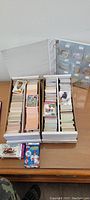 Two long boxes filled with a variety of sports cards sorted by type or player, with some cards visible on top.