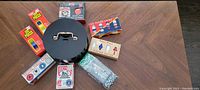 Photo showing poker chip carousel with multicolored poker chips and several packages of poker chips and playing cards arranged around it.
