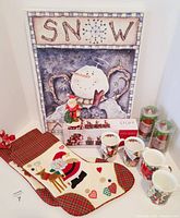 Display of Christmas stockings, snowman wall hanging, boxed Santa train decoration, four Christmas mugs, and two Christmas candles.