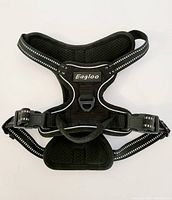 Front view of black Eagloo small dog body harness showing padded mesh chest area, adjustable straps with reflective strips, plastic quick-release buckles, and leash attachment D-ring.