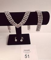 Three-piece fashion jewellery set displayed on black stand and card with lot number.