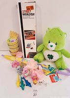 Photo of the lot including Care Bear plush, Street Invasion mini hockey set in box, new umbrella, several My Little Pony toys, and small plastic ice cream cone toys.