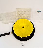 Various candy and chocolate molds along with a yellow bundt/flan mold and T-Fal frying pan shown together