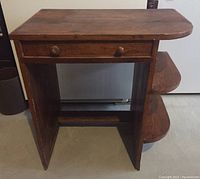 Front view showing desk top, drawer with two knobs, and open space underneath.