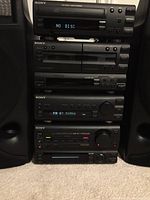 Front view of complete stereo stack with speakers showing component arrangement and brand markings.