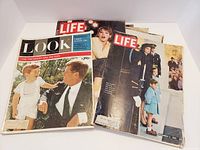 Front view of LIFE and LOOK vintage magazines, showing covers with John F. Kennedy and his son, a woman on a ladder, and a young girl in blue coat with soldier.