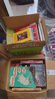 Box full of books including a children's book 'Horton Hatches the Egg' and a National Geographic book with others stacked underneath.