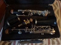 Photo showing the bundled disassembled pieces of a Bundy Selmer clarinet laid in a soft carrying case, including upper joint, lower joint, barrel, and mouthpiece.