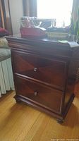 Side view of the wooden end table showing drawer fronts and knobs