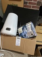Photo showing the Philips appliance, Pentax Optio 55 camera box, and cardboard box with label.