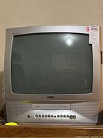 Front view of silver RCA CRT television with integrated VHS player.