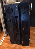 View of the front panels of the two audio devices stacked together showing control buttons and knobs, and the DVD tray on the Marantz unit.