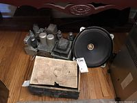 Overview of chassis parts, 8-inch speaker, and Readrite 410 tube tester with instruction paper placed together on floor.
