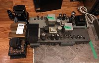 Three vintage electronic components placed on floor, showing the main DAX60 amplifier with vacuum tubes and transformers and two other components with parts and cords removed.