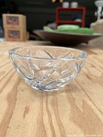 Side view of the clear glass bowl showing etched cut patterns on the sides.