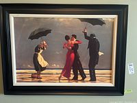 Full view of framed art print depicting a dancing couple and two umbrellas holders, woman in red dress and man in black suit dancing on beach or boardwalk.