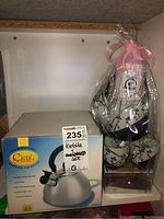 Photo of boxed stainless steel whistling tea kettle by Ciera Gourmet with product details on box.
