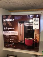 Full box front view showing Keurig K-Supreme branding and coffee maker image with black and silver finish and water reservoir