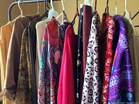 Two racks of assorted ladies clothing of varied colors and patterns on hangers showing diverse styles for different occasions.